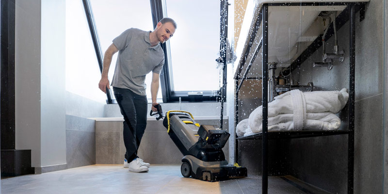 Profissional lavando piso de supermercado com equipamento