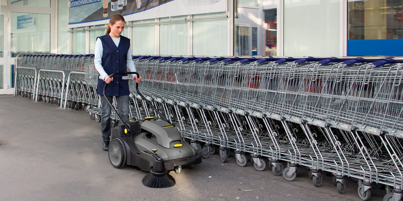 Profissional lavando piso de supermercado com equipamento