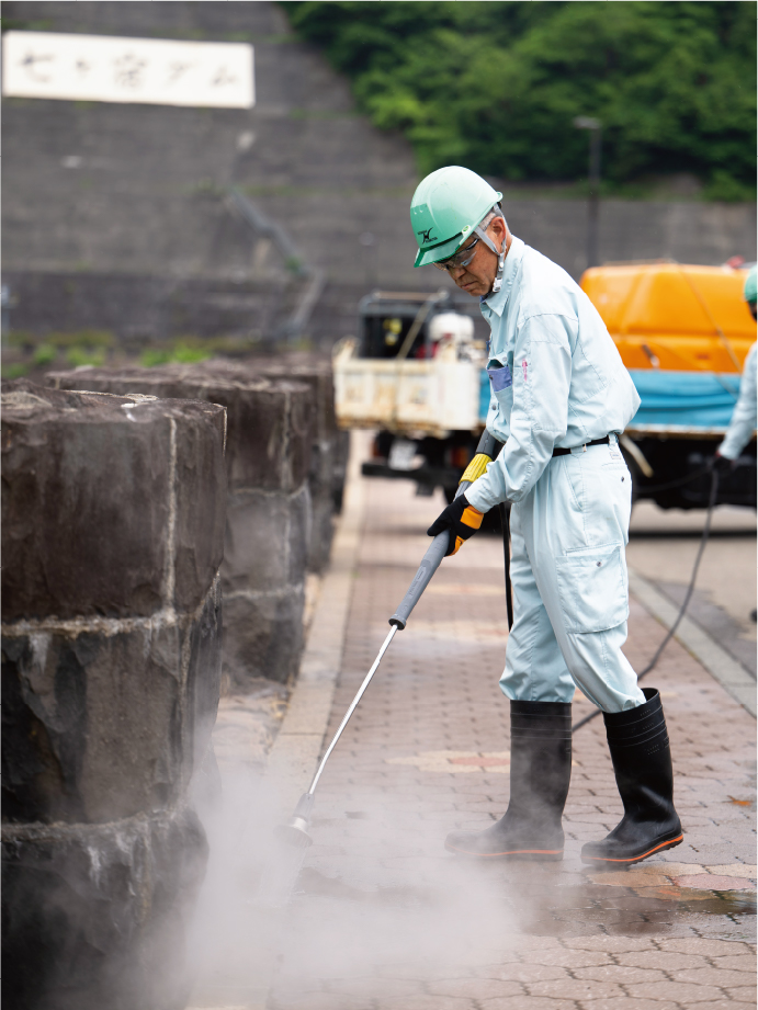 ブロック舗装の温水除草の様子。導入前は、草刈り機だとすぐに草が伸び、除草剤も使えないため、除草に頭を悩ませていた。