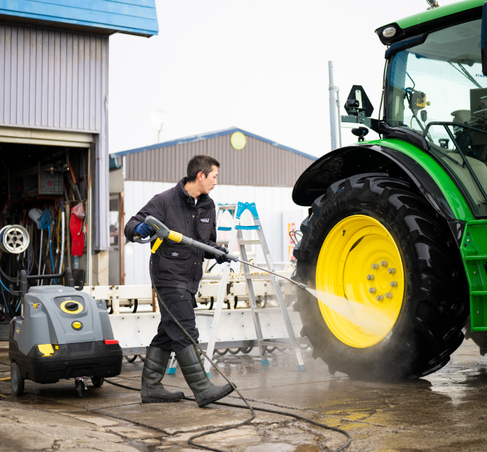 自動操縦もできる米国製の大型トラクター。温水高圧洗浄機（HDS 8/9 C）を使うことで、泥と油の汚れが楽に落とせるようになった