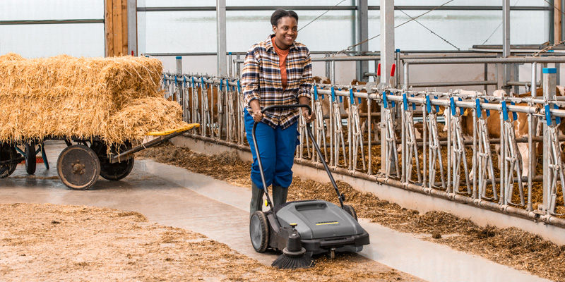 Mulher limpando fazenda de produção de gado, suínos e aves