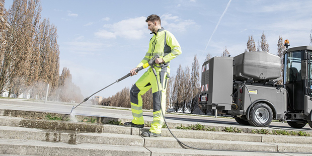 Person fjerner ukrudt på stentrappe med Kärcher professionel højtryksrenser