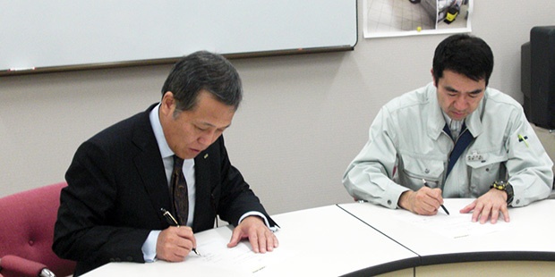 news_shinsai_02_620x310 贈呈目録にサインをする様子