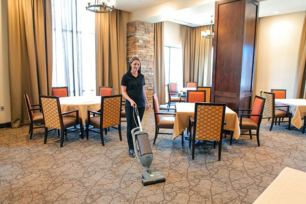 Vacuuming dining room with a WIndsor Karcher Group Upright Dual-Motor Commercial Vacuum