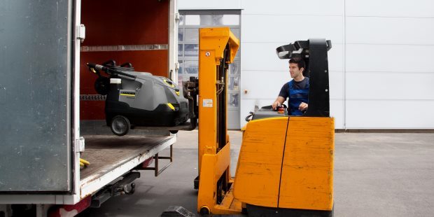 Floor sweeper lifted into trucking trailer
