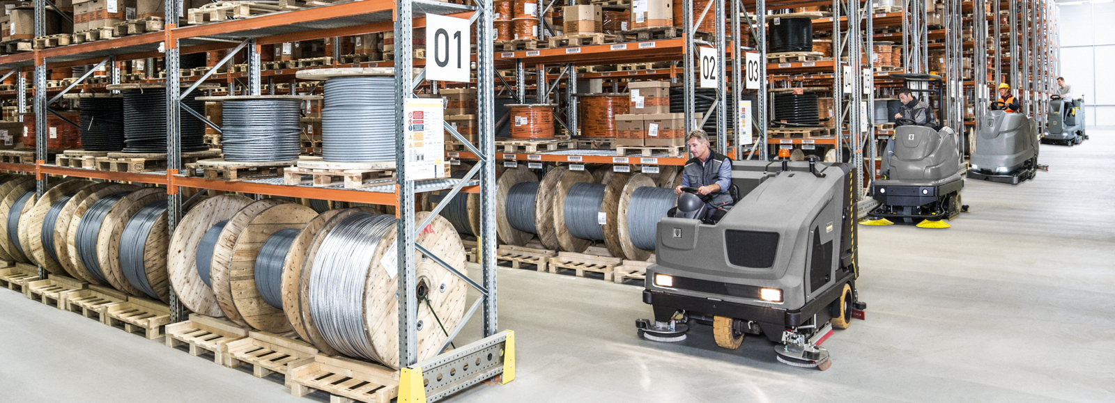 Scheuer- und Kehrsaugmaschine. Scheuer- und Kehrsaugmaschinen in einer Logistikhalle.