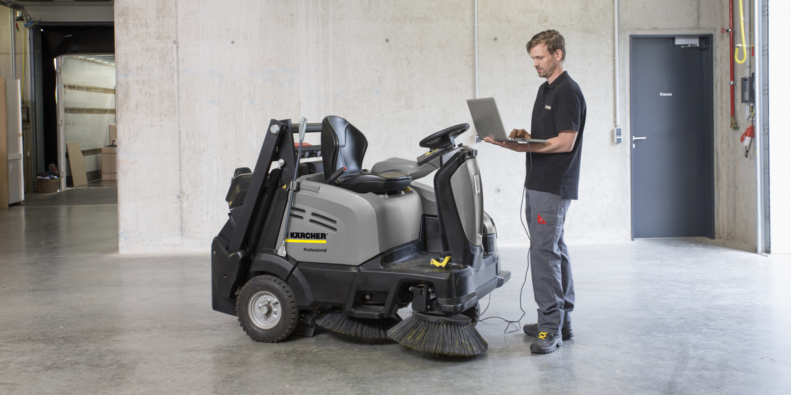 Servicemitarbeiter mit Laptop und Scheuersaugmaschine Servicemitarbeiter mit Laptop und Scheuersaugmaschine