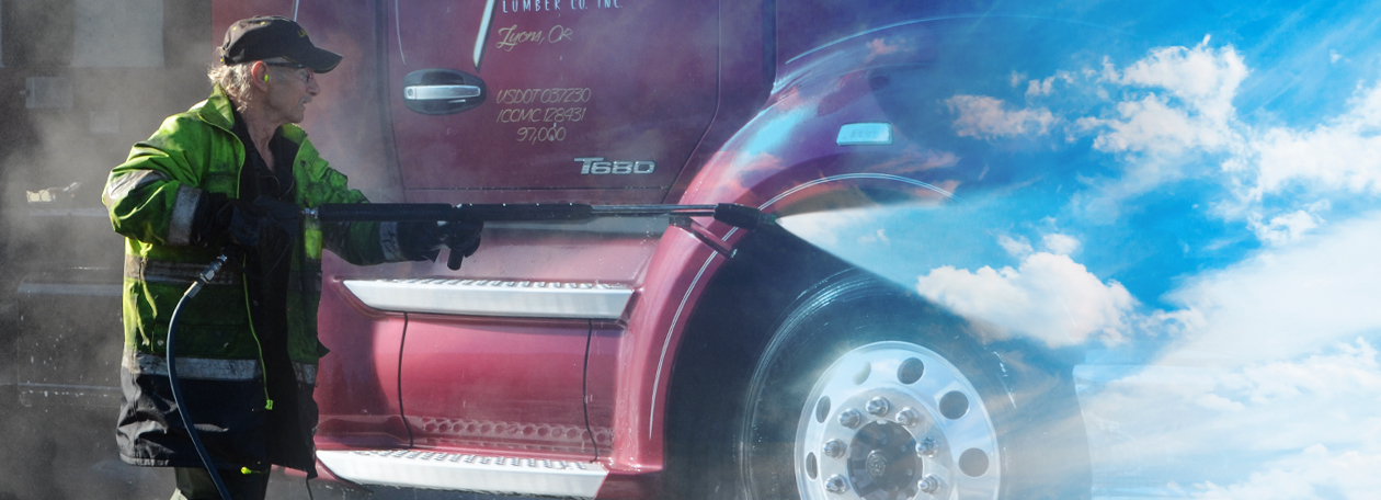 Pressure Washing In A Future of Zero Emissions Worker pressure washes a semi truck