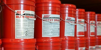 Wide Selection A series of Hotsy 5-gal soap buckets are aligned on a shelf