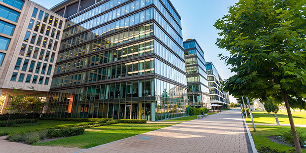 Contract Cleaning Industry Clean walking areas sit along a row of glass commercial structures.