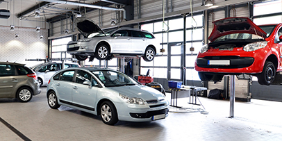 Automotive Industry An automotive service shop with cars on hydraulic lifts and on the ground.