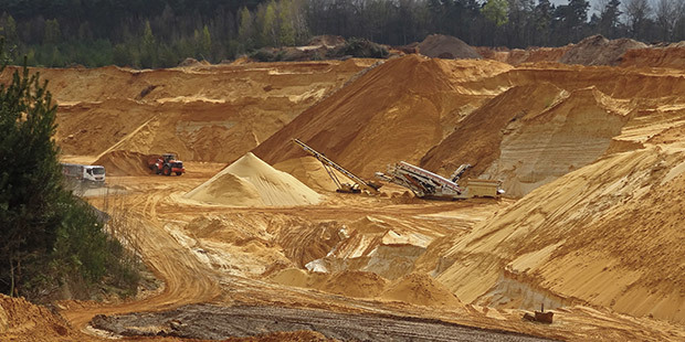 Mining & Drilling Industry Industrial equipment operate inside a massive mining site.