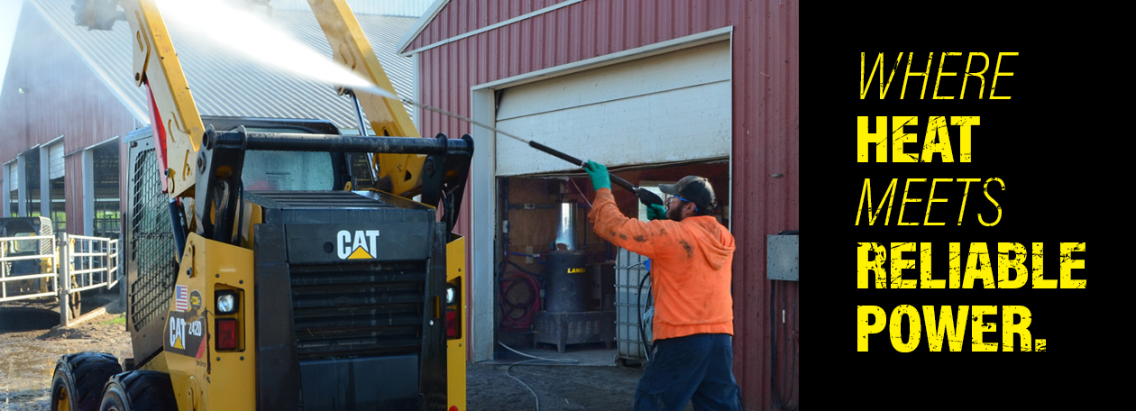 Electric Hot Water Pressure Washers A worker cleans construction equipment with a Landa electric hot water pressure washer.