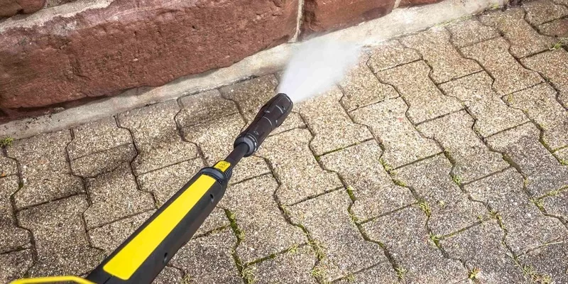 Cleaning the edge of the paving stone with a Kärcher pressure washer