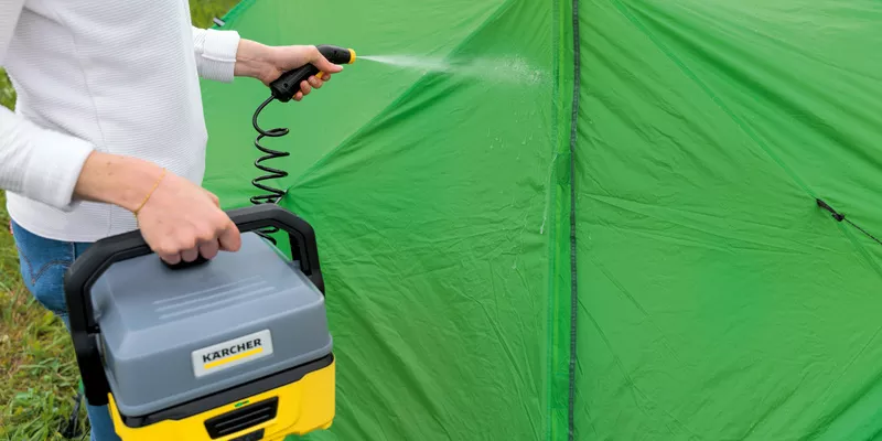 A green tent being cleaned with a Kärcher OC 3