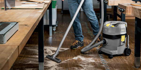 Optimal airflow rate A worker using a vacuum to collect dirt off a hardwood floor.