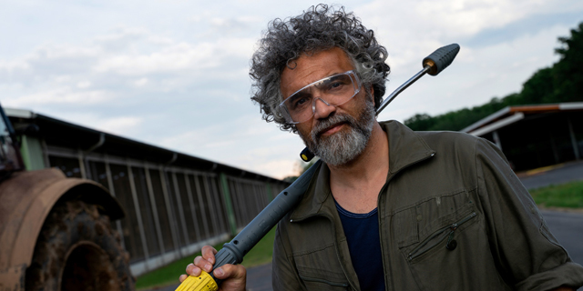 Extremely Efficient A man stands with a Kärcher pressure washer wand slung over his shoulder