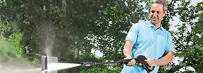 Garden furniture cleaning Man using Karcher Pressure washer in cleaning garden furniture