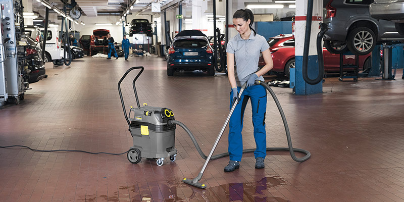 Automotive Dealerships & Service Centers Auto shop worker cleans a spill with a Kärcher commercial wet dry vacuum