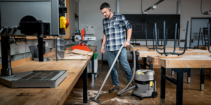 Schools and Colleges A worker uses a Kärcher commercial wet dry vacuum to collect dust on a shop classroom floor