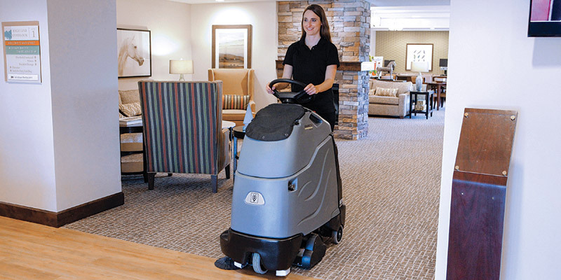 Senior Living Facilities A worker uses a Kärcher commercial stand-on vacuum in a senior living facility