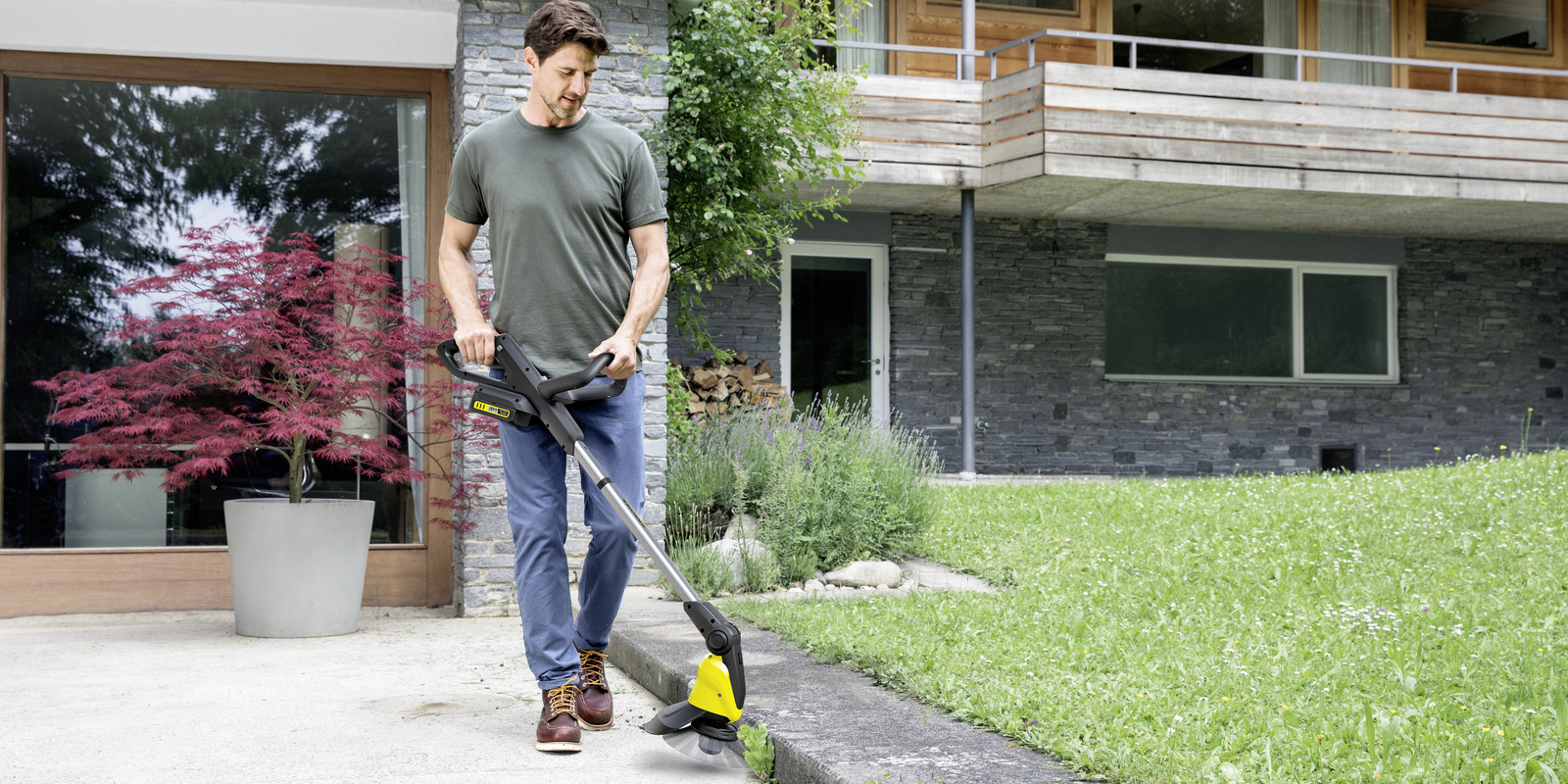 Man is removing weeds with a Kärcher Weed Remover