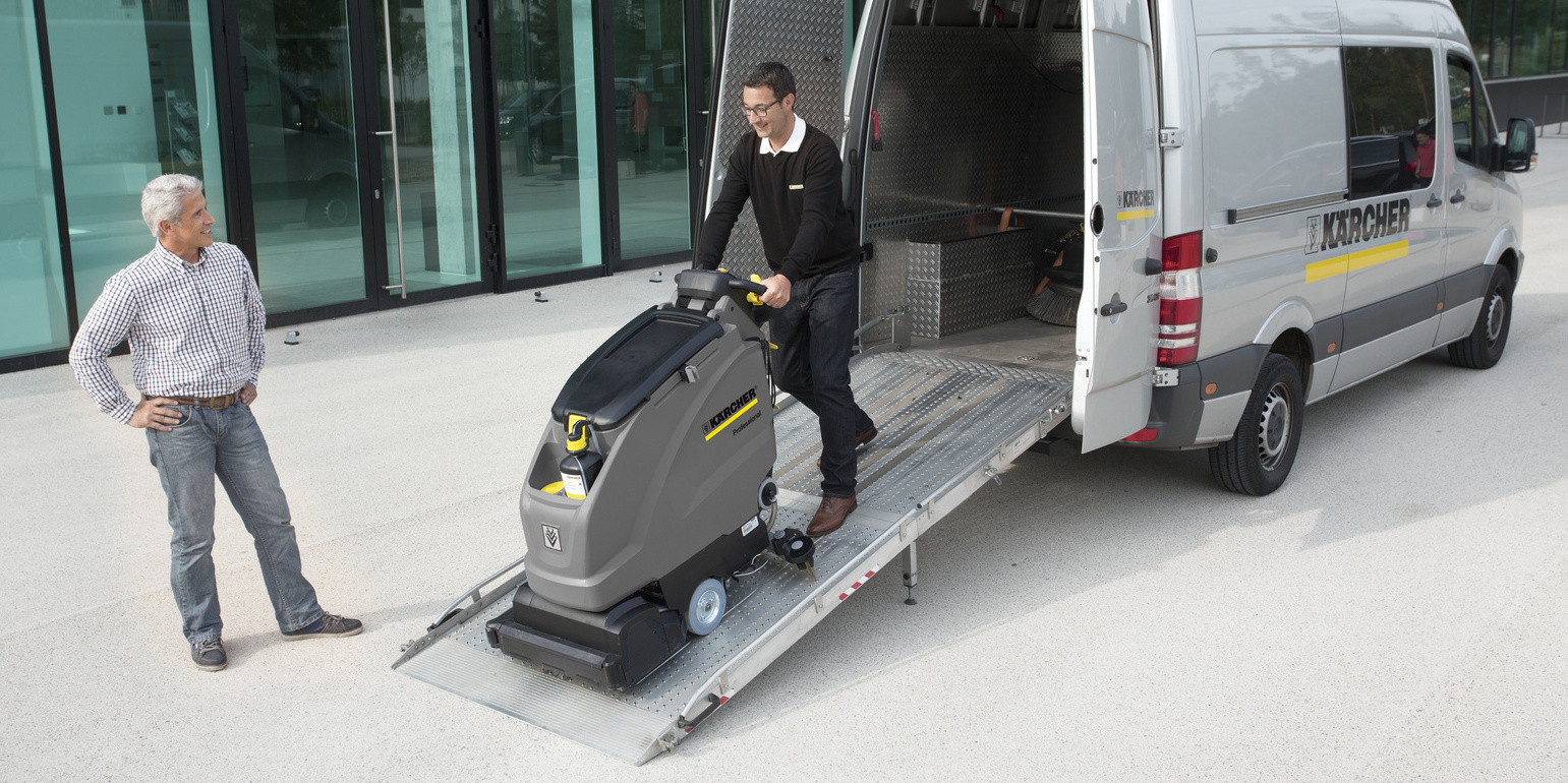 Kärcher Rental Service A Kärcher rep pushes a walk-behind floor scrubber out of his van for a customer.