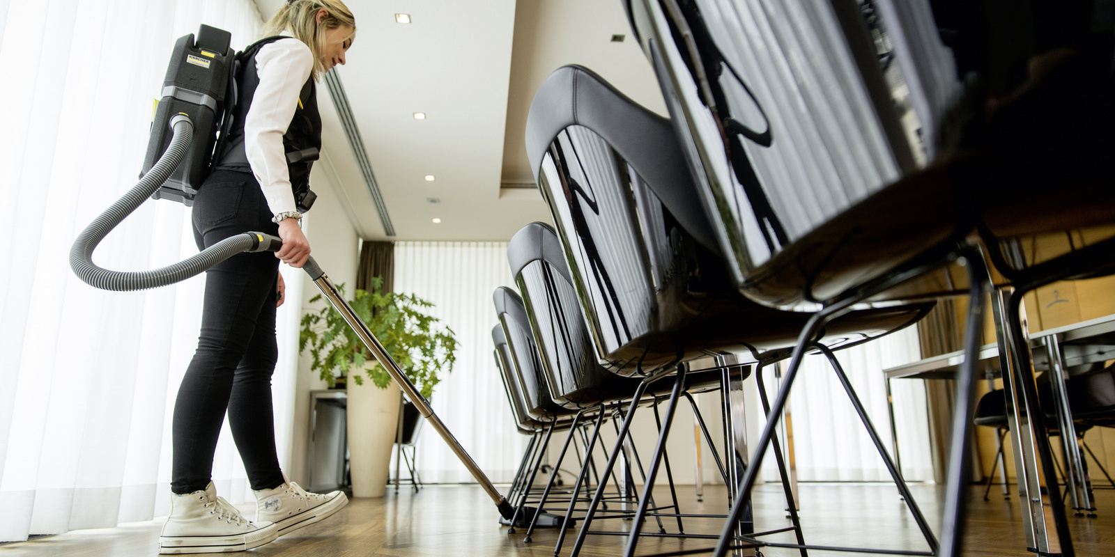 A battery-powered dry vacuum cleaner cleaning a conference room A Kärcher battery-powered dry vacuum cleaner cleaning a conference room