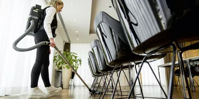 A Kärcher cordless dry vacuum cleaner cleans a conference room
