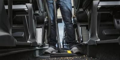 Cleaning a bus with a Kärcher battery-powered dry vacuum cleaner.