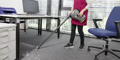 Cleaning an office with a Kärcher battery-powered dry vacuum cleaner.