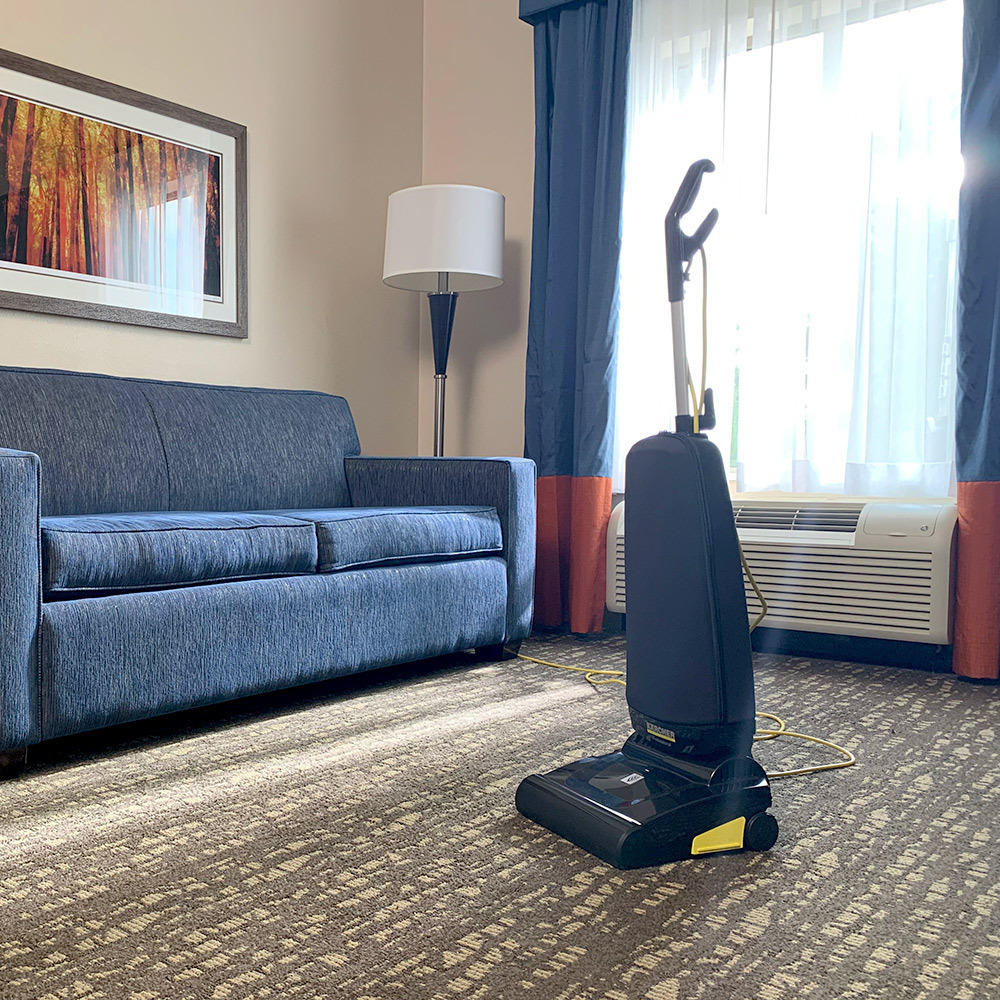 Hotel room carpet cleaning Kärcher Ranger upright vacuum stands in a hotel room