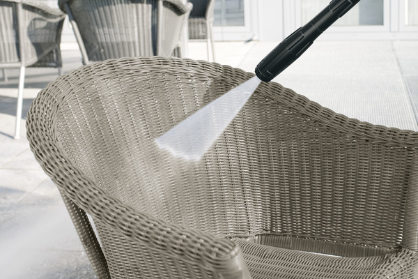 Nettoyer le mobilier de jardin en rotin Une chaise en rotin est nettoyée avec de la mousse