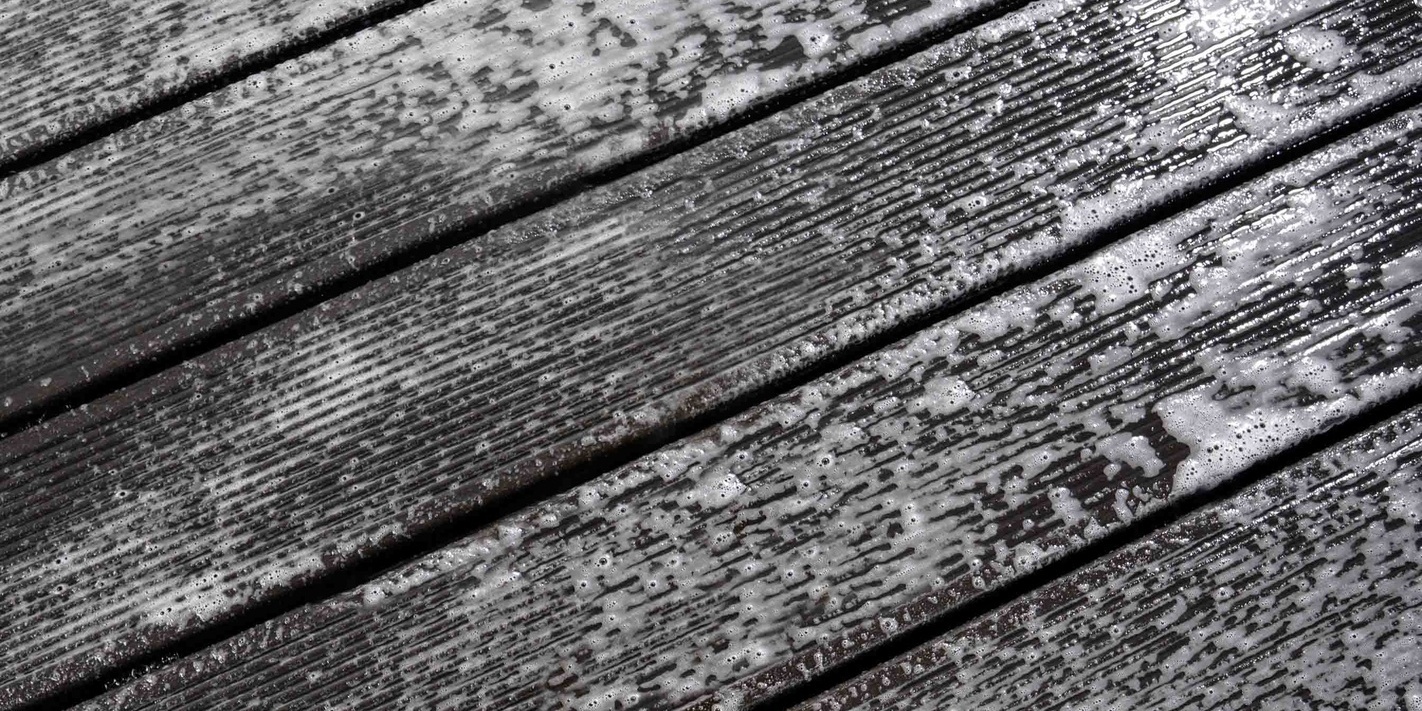 Nettoyer une terrasse en bois avec un produit de nettoyage Une terrasse en bois recouverte de mousse