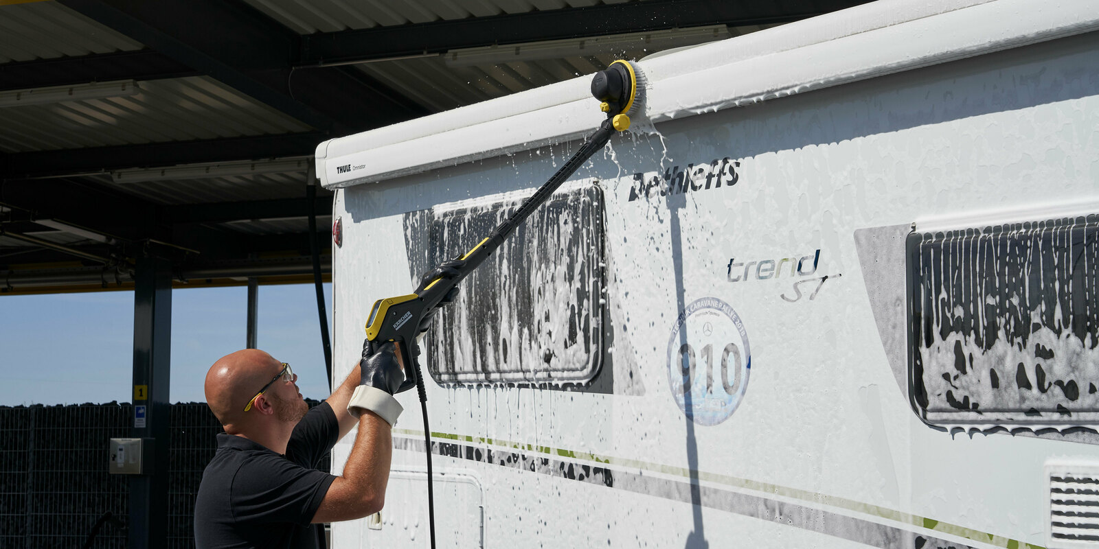 Nettoyer son camping-car avec de la mousse Un homme nettoie son camping-car avec un nettoyant Kärcher