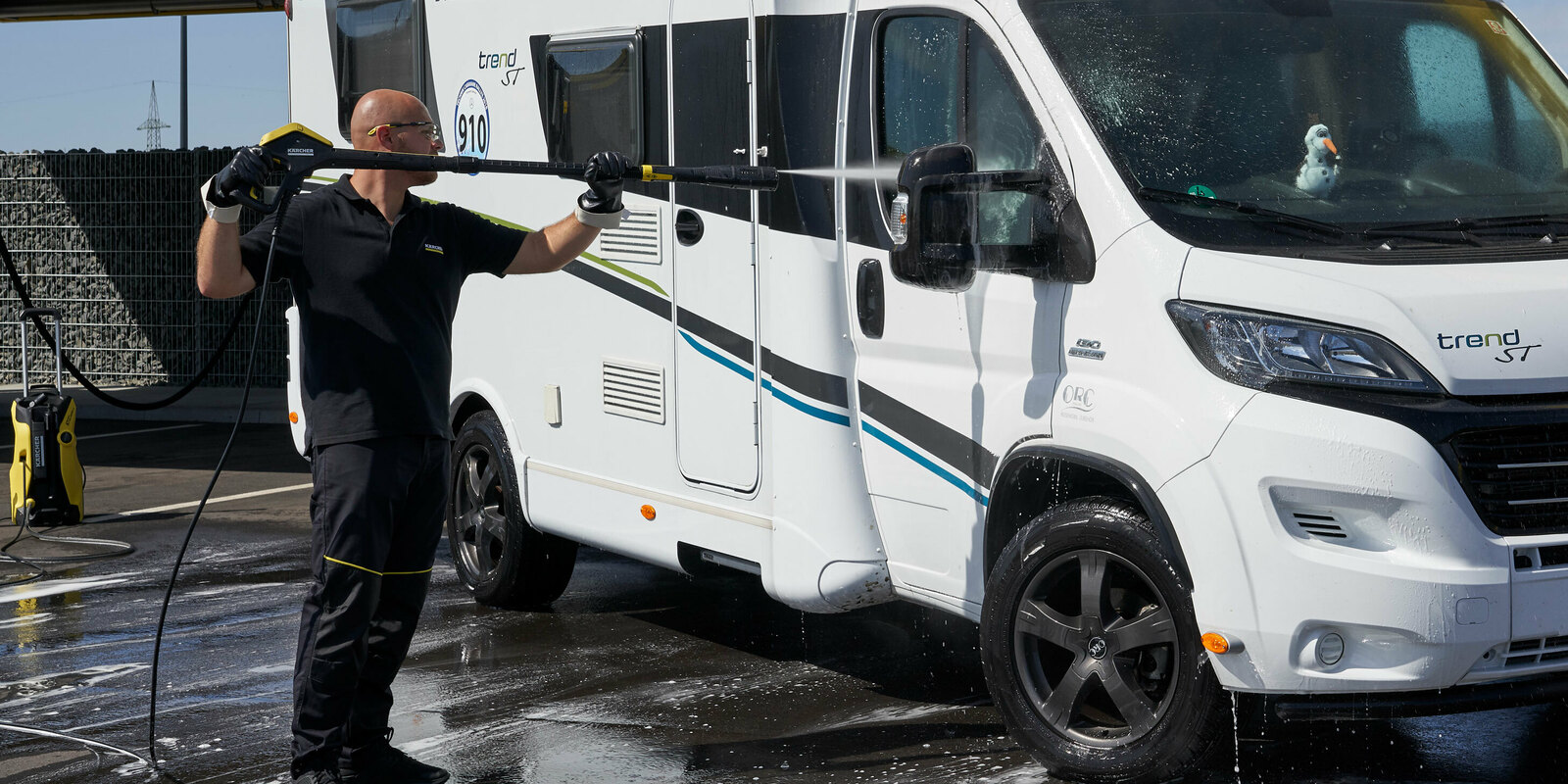 Nettoyer les vitres du camping-car à haute pression Un homme nettoie les vitres du camping-car avec un nettoyeur haute pression Kärcher