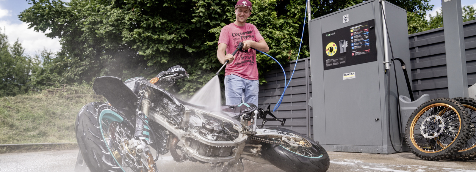 Nettoyer une moto en station de lavage Un homme nettoie sa moto dans une station de lavage Kärcher