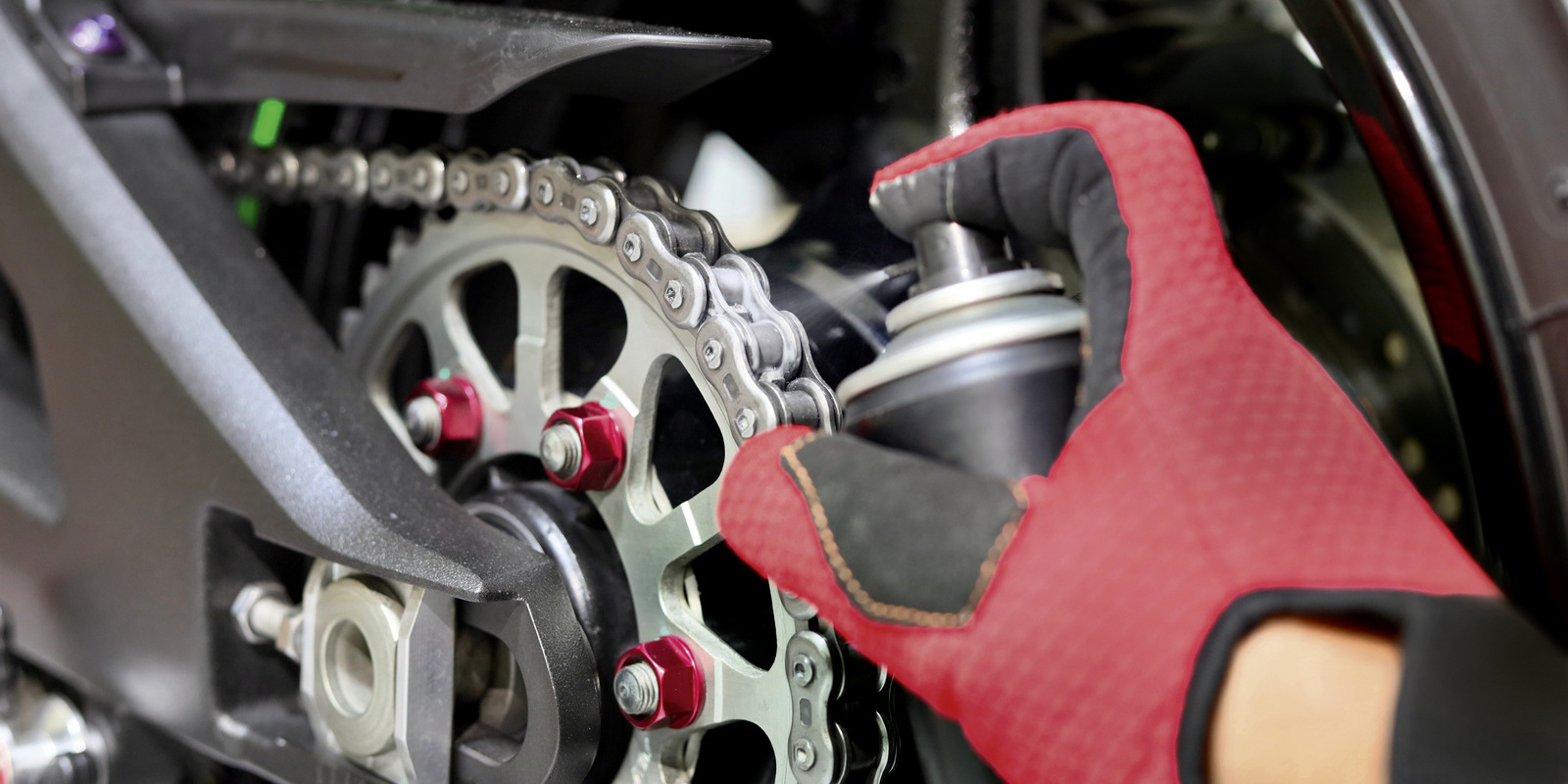 Nettoyer la chaîne de moto avec un spray lubrifiant pour chaîne Kärcher: la chaîne de moto est nettoyée avec un spray lubrifiant pour chaîne