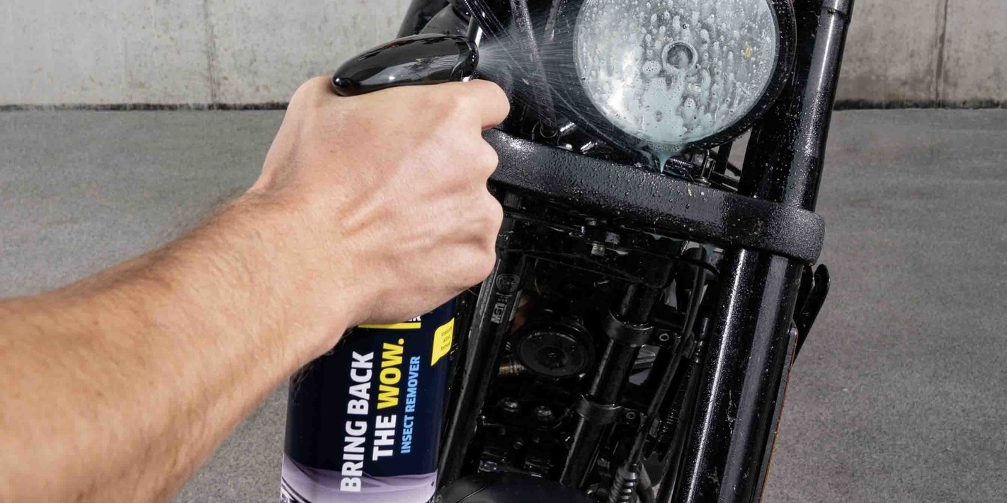 Produit insecticide détergent sur les phares Le produit insecticide détergent de Kärcher est vaporisé sur un phare de moto