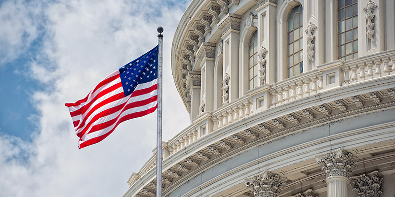 An American flag waves in front of the U.S. Capitol dome