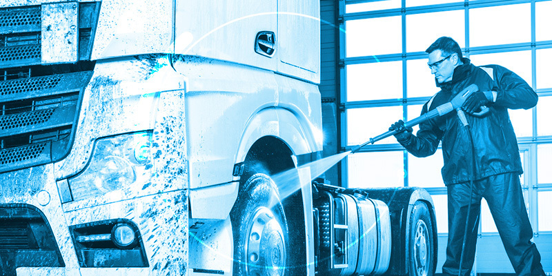 Illustration of a worker pressure washing a truck
