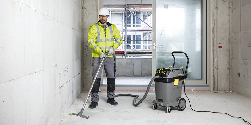 Expand Your Reach With Floor Care A worker uses a wet-dry vacuum to clean at a construction site