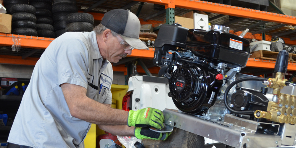 A service technician tunes up a Landa pressure washer