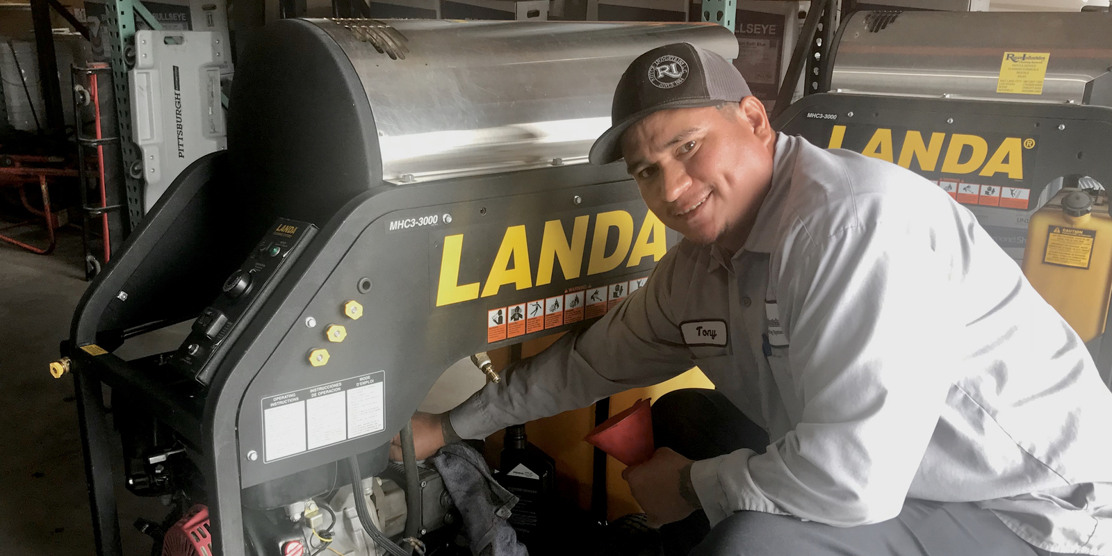 A technician tunes up a Landa pressure washer