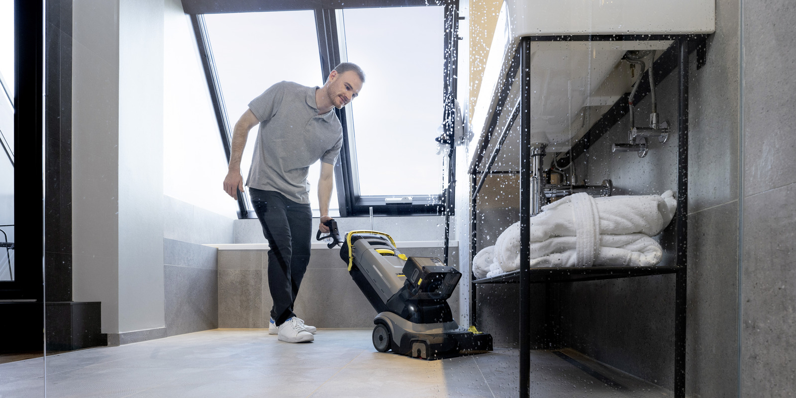 Compacte Kärcher schrobmachine in gebruik Man reinigt vloer met een compacte Kärcher schrobmachine