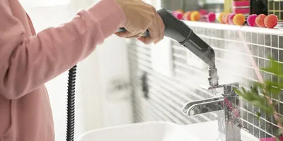 Reinigung des Wasserhahns mit Dampfreiniger mit Bürstenaufsatz