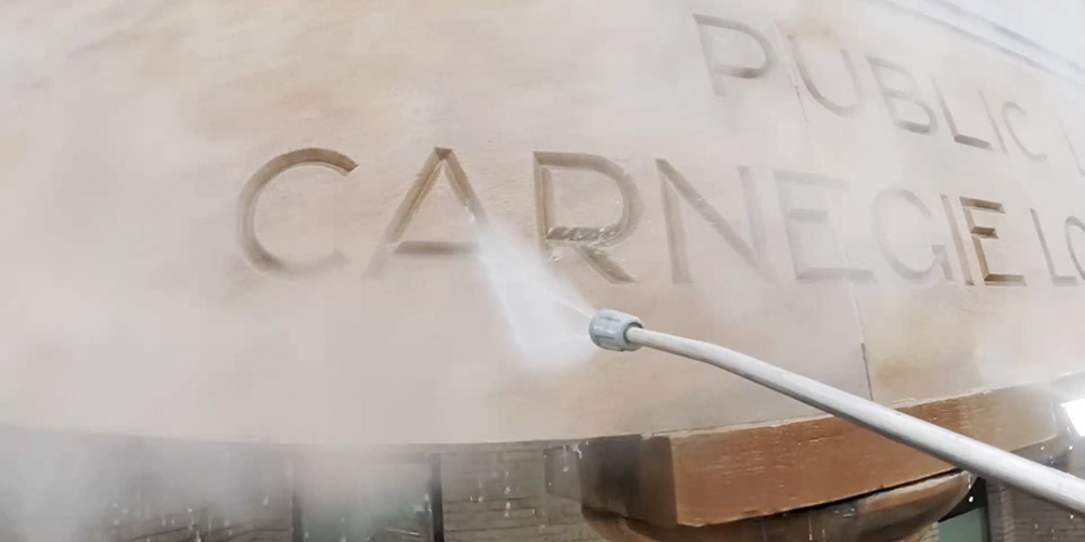 Delicate cleaning of Carnegie Lorain Library lettering A pressure washer uses low pressure to clean the exterior of the library