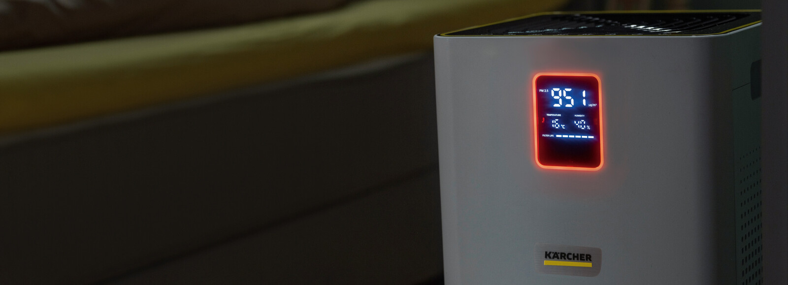 Oczyszczacz powietrza Kärcher AF 30 w trybie nocnym. W tle kobieta śpi na łóżku.