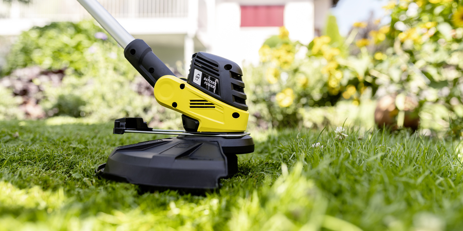 Protective cover Close-up view: the Kärcher battery lawn trimmer with protective bonnet in action