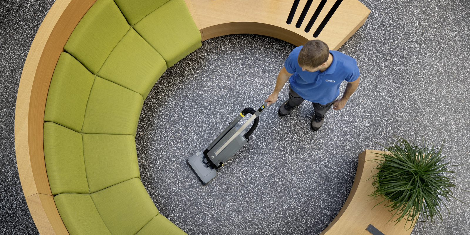 Cleaning technology in building cleaning A person cleaning the carpet with an upright brush vacuum cleaner